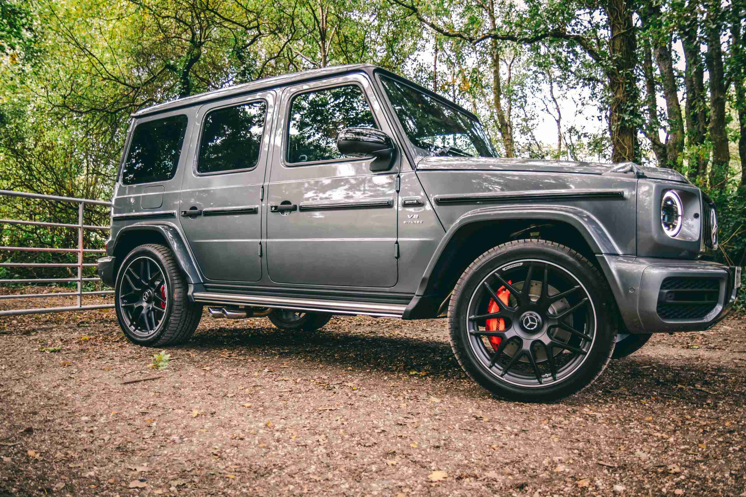insurance crm A luxurious Mercedes-Benz SUV parked in a scenic wooded area, showcasing elegance and power.